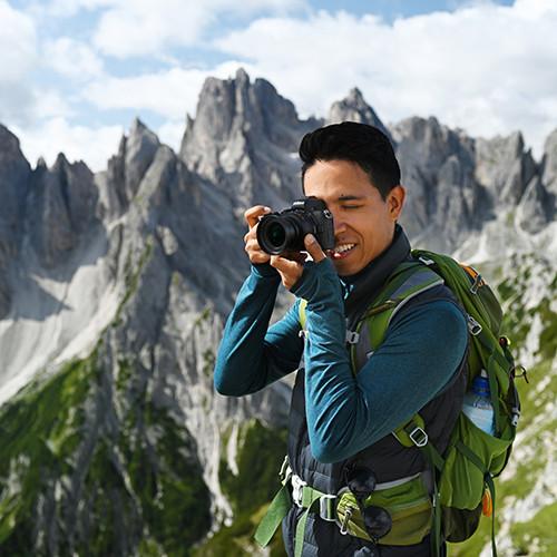 Hiker photographing mountain landscape