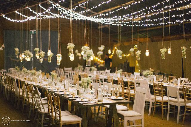 DIY fairy light wedding decorations hanging above reception tables
