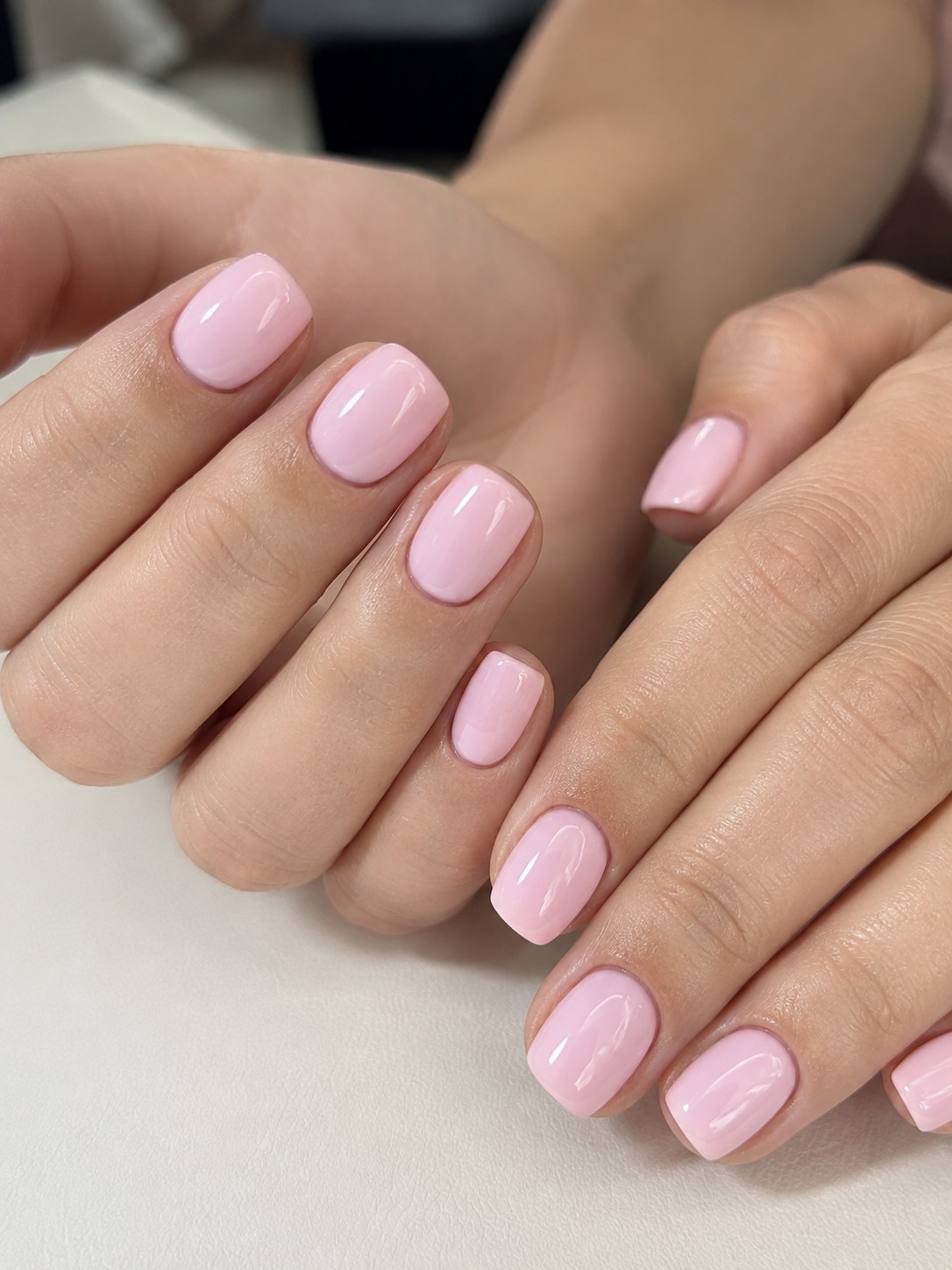 Close-up of solid bubblegum pink coffin nails short with a high-gloss top coat