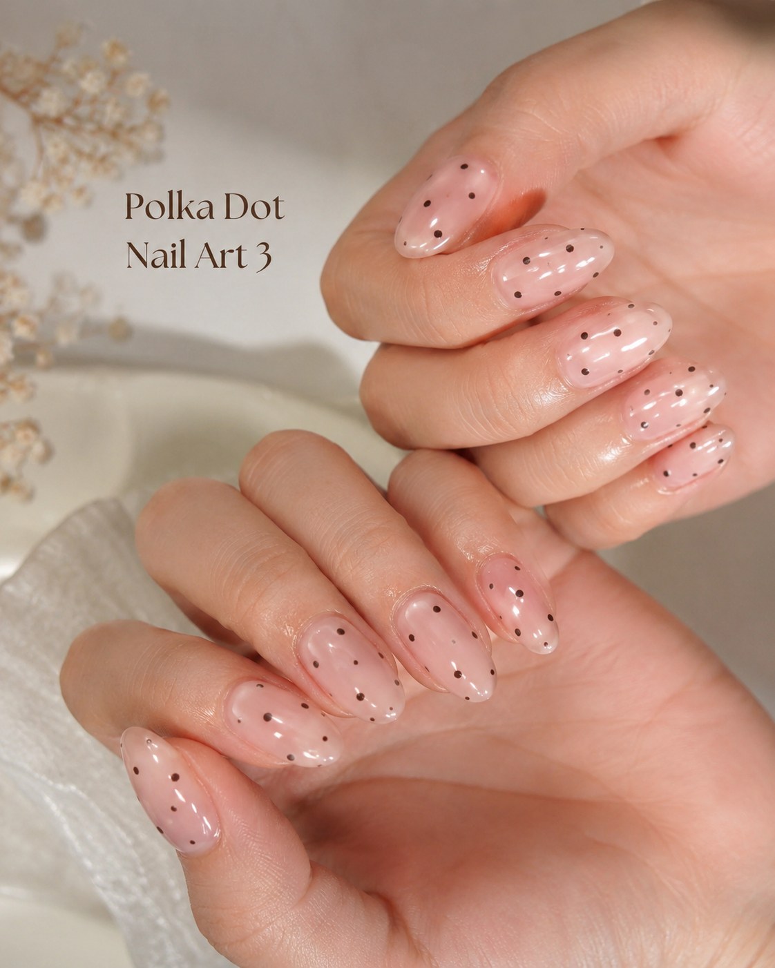 Sheer jelly pink polka dot nail art with scattered black dots on natural short nails