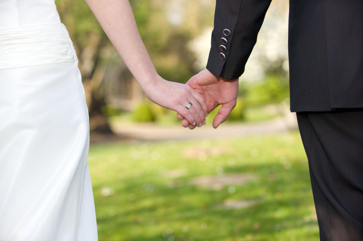 Newlywed couple holding hands romantically