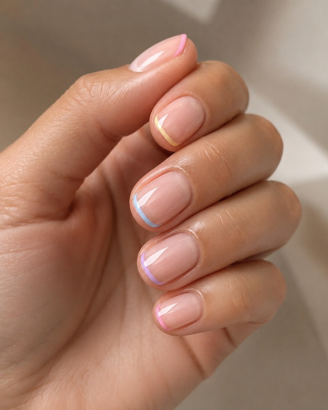 Pastel rainbow short french tip nails with soft ombre-colored tips for spring