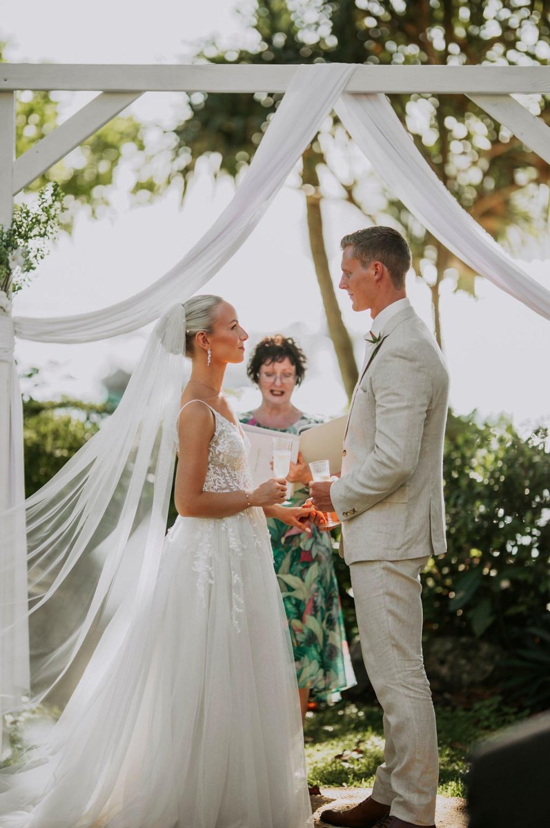 Couple exchanging vows under arch