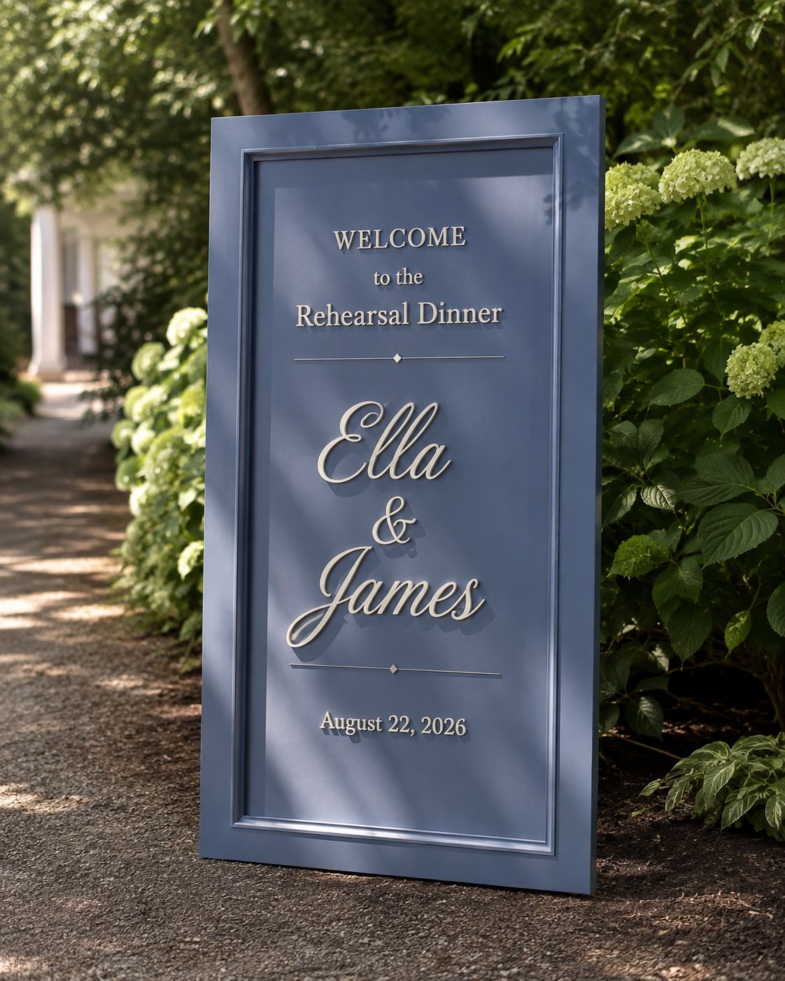 Navy framed rehearsal dinner sign greets guests along a hydrangea-lined garden path